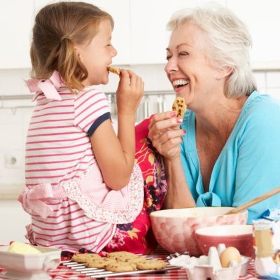 grandma and grandchild baking and eating cookies